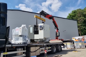 Machine being lifted off a truck by crane