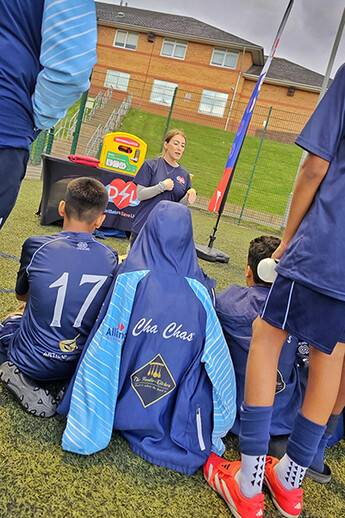 Heart Hero and Trustee Ash Teaching CPR at Football